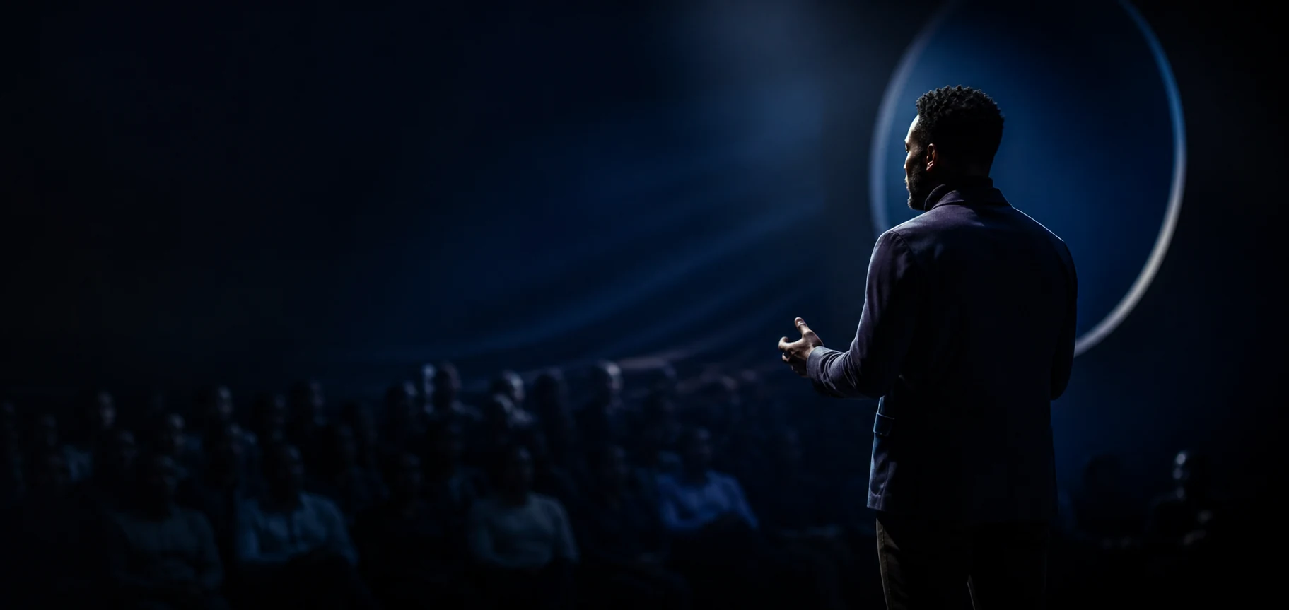 Un storyteller s’adresse à son audience sur une scène éclairée